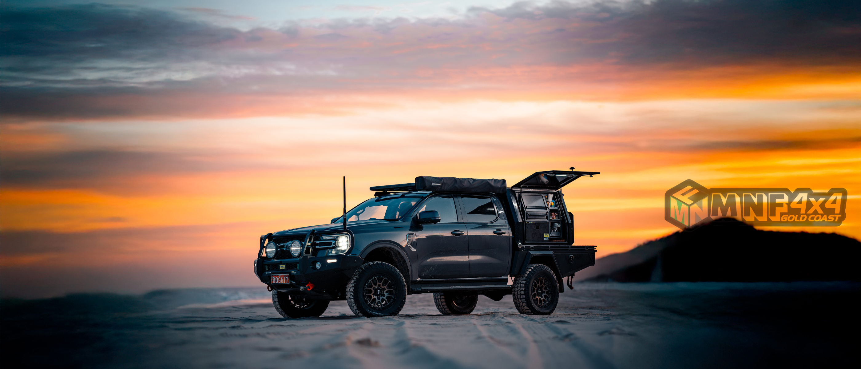 MNF 4x4 built ute with rooftop tent and canopy kitchen setup at sunset on the beach, Gold Coast